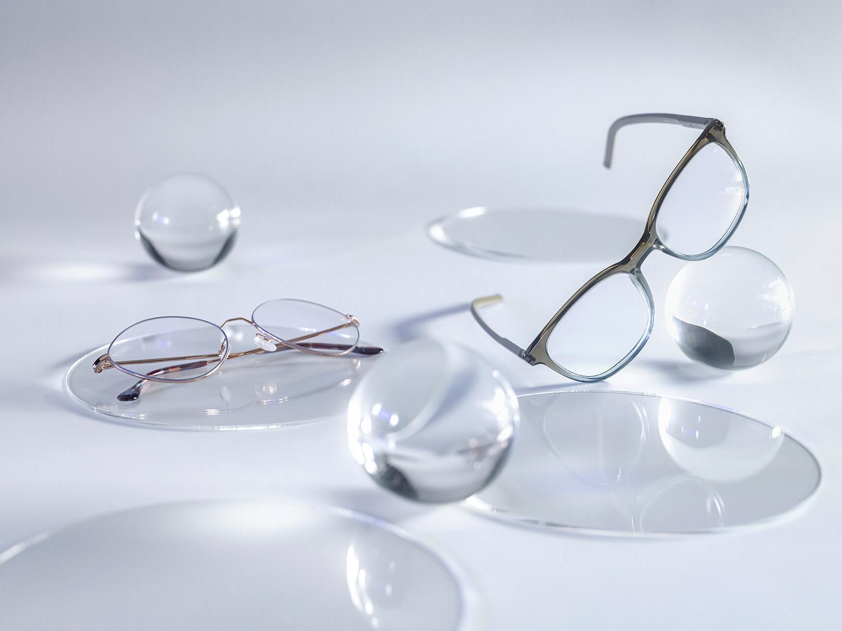 Naočale sa ZEISS lećama koje imaju DuraVision® Silver sloj i ne pokazuju refleksije u usporedbi s okolnim staklenim kuglama.