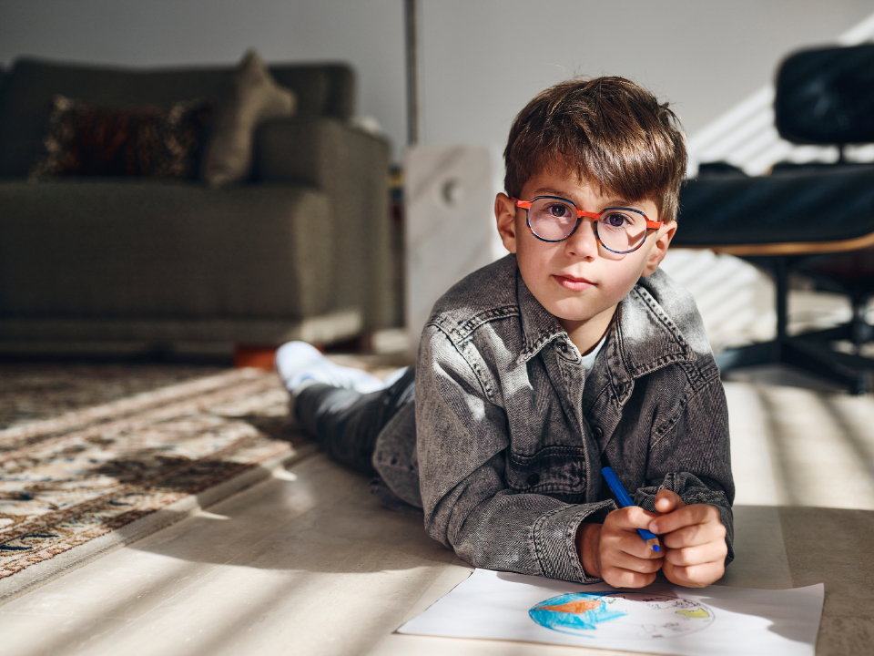 Dječak koji nosi ZEISS MyoCare leće gleda ravno u fotoaparat.