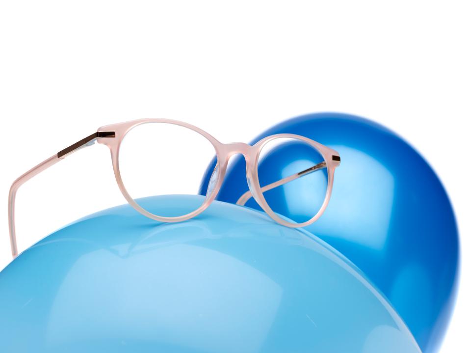 Ružičasti okvir za naočale sa ZEISS MyoCare lećama na plavom balonu.