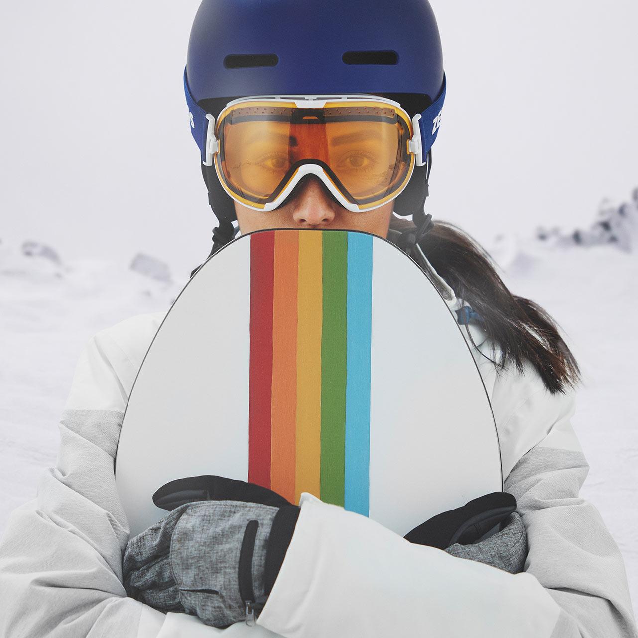 Žena nosi plavu kacigu i ZEISS naočale za skijanje s prozirnim vizirom.
